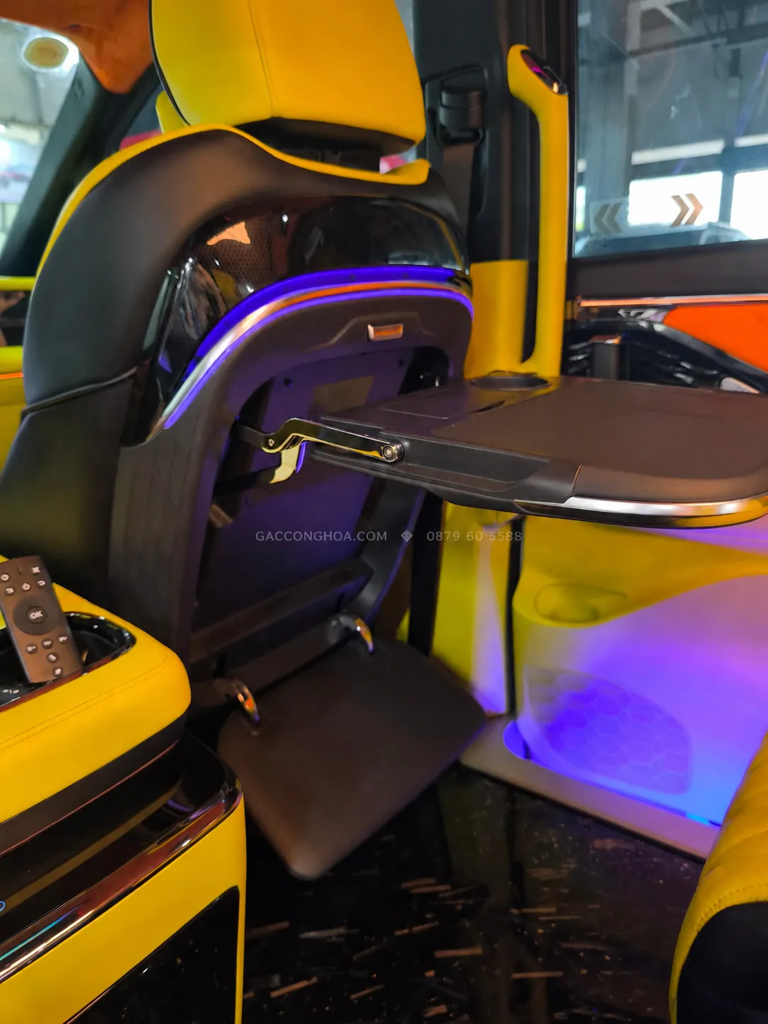Bàn làm việc gấp gọn sau ghế trước trong khoang GAC M8 limousine với đèn viền xanh